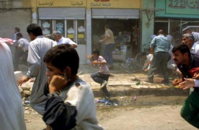 Iraqis flee the scene after a bomb explosion in Baquba northeast of Baghdad