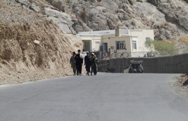 Afghan boys walk along in front of Mullah