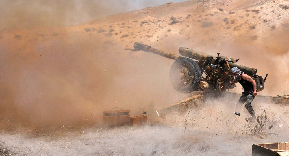 A Syrian army soldier fires artillery shells towards Islamic State group jihadists in northeastern Palmyra