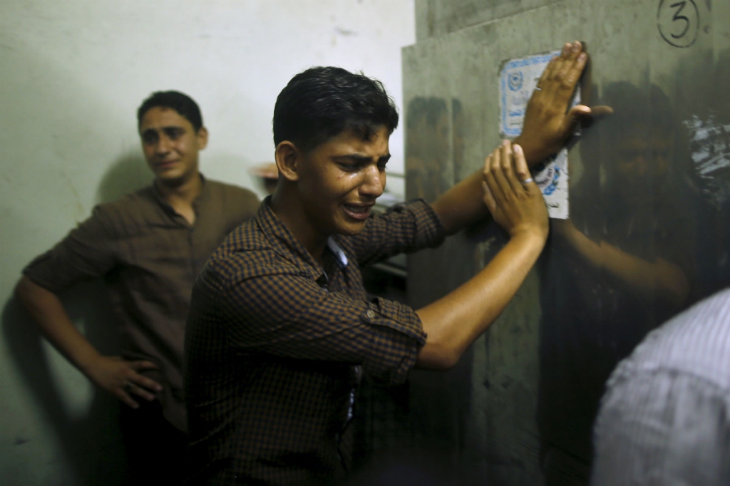 Friends of Palestinian teen Mohammed Al-Masri 17 whom medics said was shot and killed by Israeli forces mourn at a hospital morgue in the northern Gaza Strip