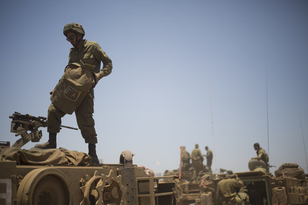 Israeli soldiers stand on top of armored military vehicles during training exercises in the Israeli-occupied Golan Heights near the border with Syria