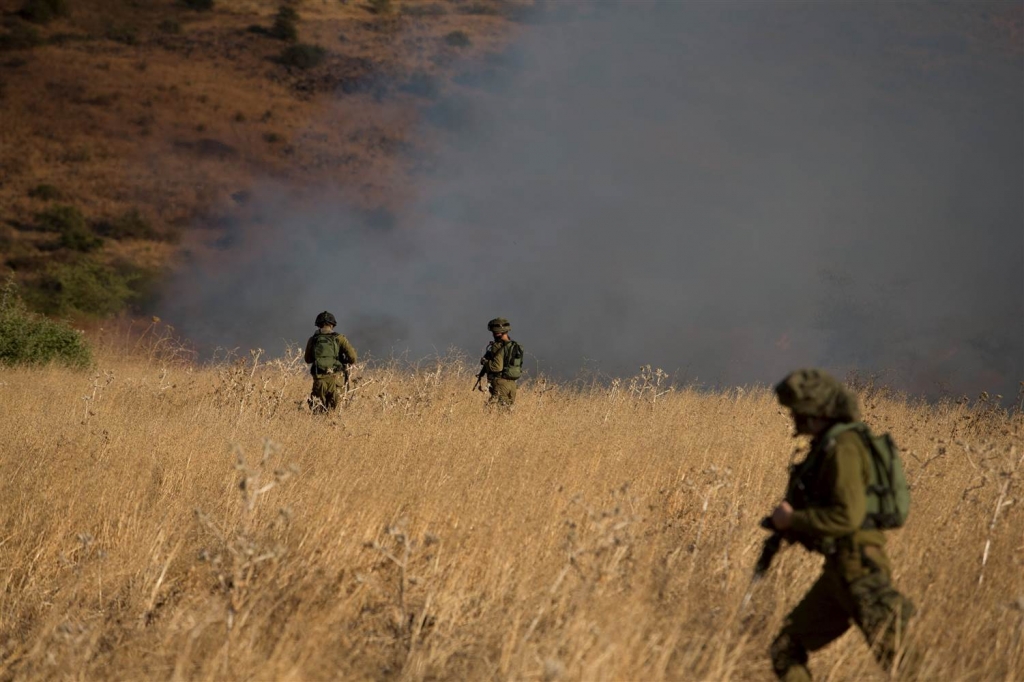 Image Israeli soldiers patrol next to a smoke from a fire caused by a rocket attack in northern Israel near the Lebanese border