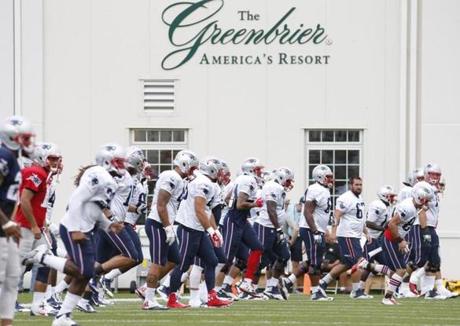 New England Patriots players warm up during a joint practice with the New Orleans Saints at the Saint's NFL football training camp in White Sulphur Springs