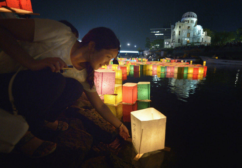 A woman sets a floating candle lantern on the river Aug. 6 in Hiroshima Japan. The lanterns thousands of which were launched on the 70th anniversary of the atomic bombing of the city bear handmade messages and drawings conveying each person's prayers