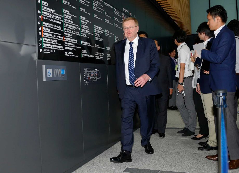 International Olympic Committee Vice President John Coates leaves a press conference after meeting with Japan's Olympics Minister Toshiaki Endo in Tokyo Tuesday Aug. 25 2015. The top International Olympic Committee official has urged Japan to speed