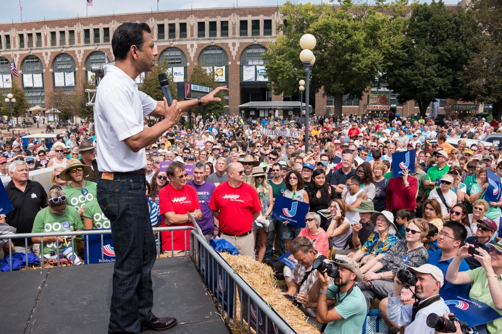 Republican presidential candidate Bobby Jindal is interrupted during his speech by protesters chanting and holding a sign'citizenship now by the Political Soapbox Jindal says big business is financing groups like this to protest during his speeches