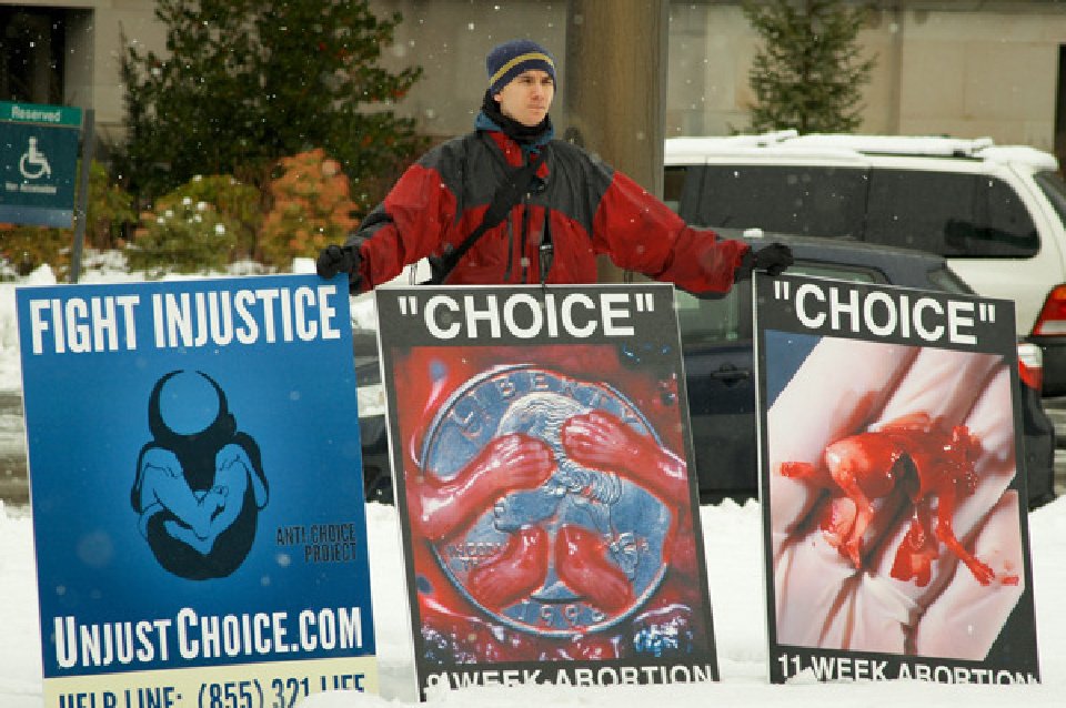 Choice Project member holds anti-abortion signs during the 2012 March for Life in Olympia Wa. For use ONLY with RNS-ROE-GRAPHICS transmitted