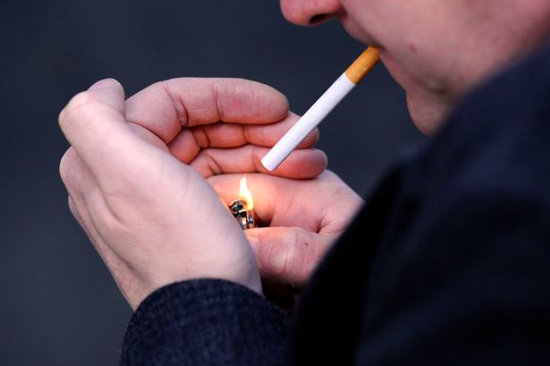 A man lighting a cigarette