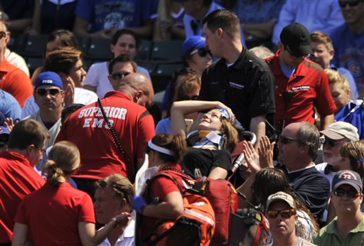 A fan is carried away after being hit a by a line-drive foul ball during the first inning of a baseball game between the Chicago Cubs and the Atlanta Braves at Wrigley Field Sunday Aug. 23 2015 in Chicago