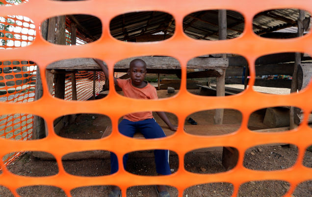 Adama Sankoh 40, who contracted Ebola after her son died from the disease late last month stands with health officials the moment after she was discharge from Mateneh Ebola treatment center outskirt of Freetown Sierra Leone