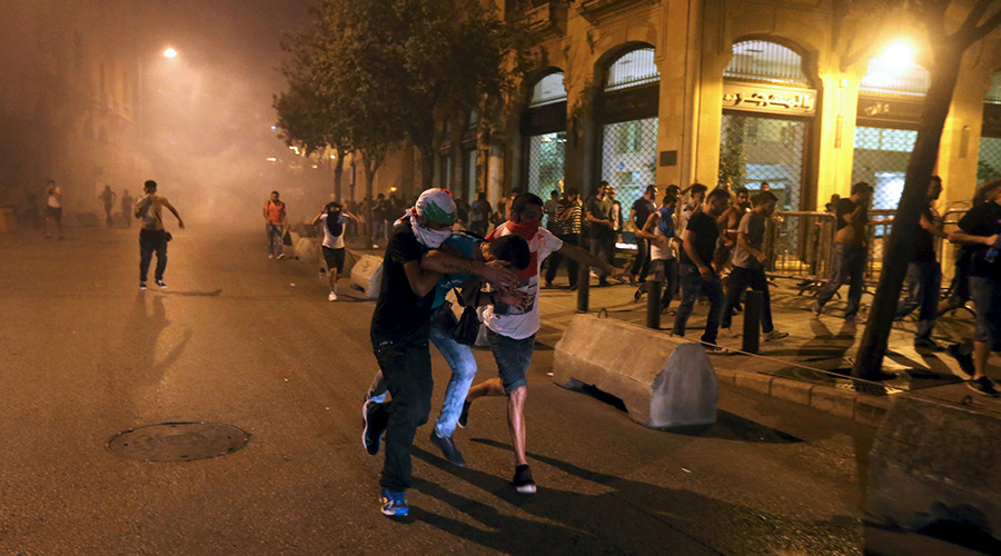 Protestors run during a protest against corruption and rubbish collection problems near the government palace in Beirut