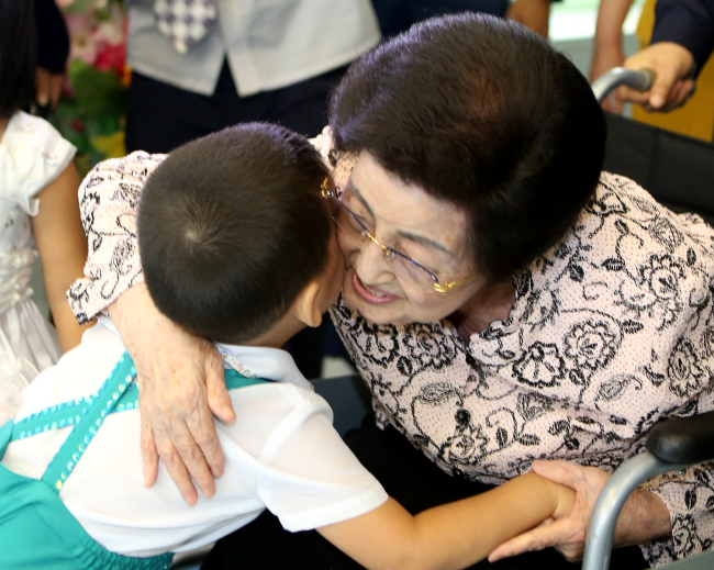 Lee Hee-ho hugs a child during her visit to Aeyukone an orphanage for kindergarteners in Pyongyang last Thursday. Kim Dae-jung Peace Center