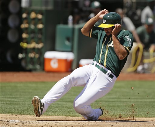 Oakland Athletics&#039 Marcus Semien slides into home plate to score the Athletics&#039 first run in the third inning of their baseball game against the Baltimore Orioles