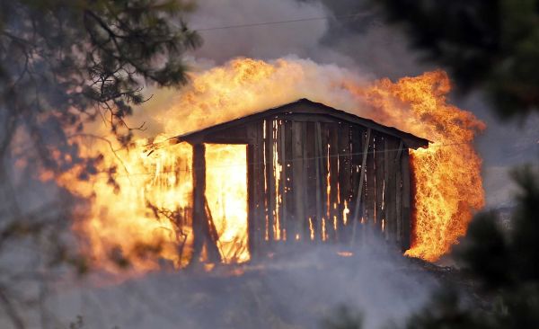 Flames pour from a structure fully engulfed