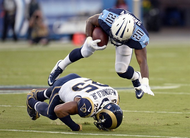 Tennessee Titans running back Bishop Sankey is tripped up by St. Louis Rams strong safety T.J. Mc Donald during the first half of a preseason NFL football game Sunday Aug. 23 2015 in Nashville Tenn