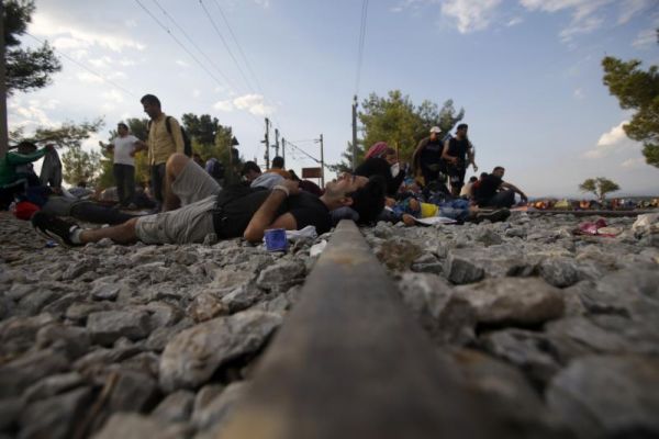 Migrants rest near the border train station