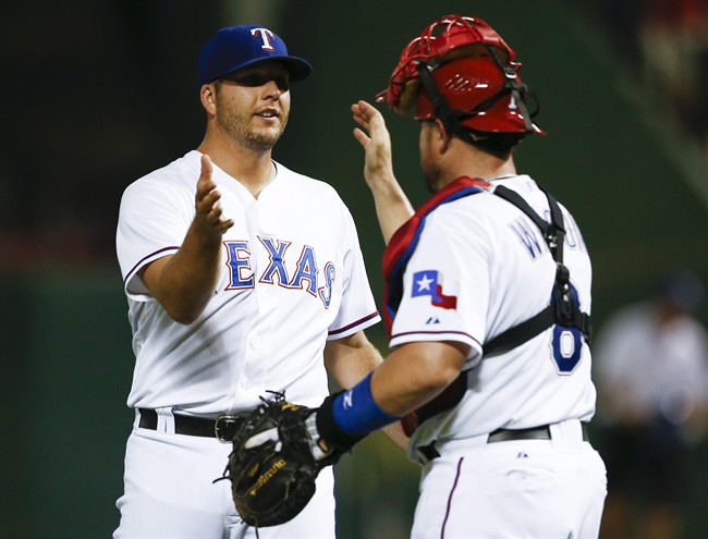 Texas Rangers relief pitcher Shawn Tolleson left and catcher Bobby Wilson congratulate each other following the Rangers 12-9 win over the Houston Astros during a baseball game Monday Aug. 3 2015 in Arlington Texas. The Rangers won 12-9. (AP Pho