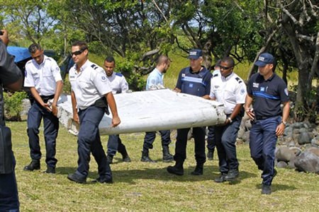 29 2015 French police officers carry a piece of debris from a plane in Saint-Andre Reunion Island. Malaysian officials said Sunday Aug. 2 2015 that they would seek help from territories near the island where a susp