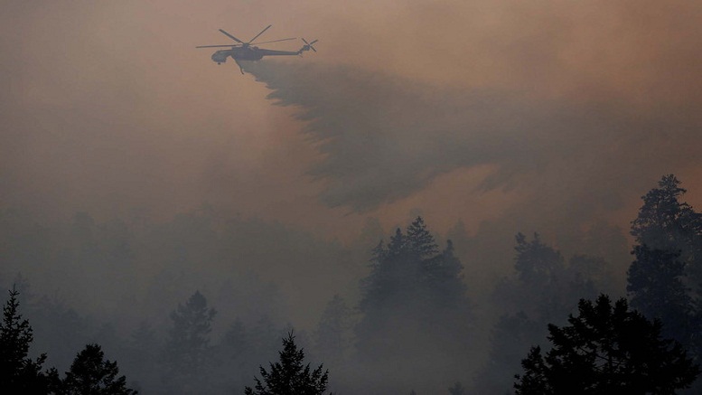 An Erikson Sky Crane drops a load of water on the First Creek Fire in the Lake Chelan State Park on Sunday