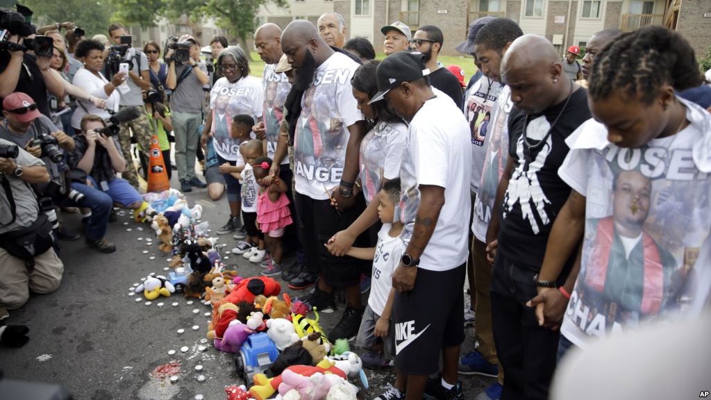 Michael Brown Sr. with beard along with family and friends stops to pray at a memorial to his son Michael before taking part in a march in his son's honor in Ferguson Missouri Aug. 8 2015