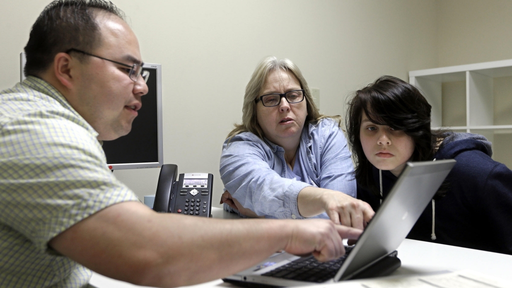 Enrollment counselor Vue Yang reviews health insurance options for Laura San Nicolas, accompanied by her daughter Geena 17 at Sacramento Covered in Sacramento Calif. in February