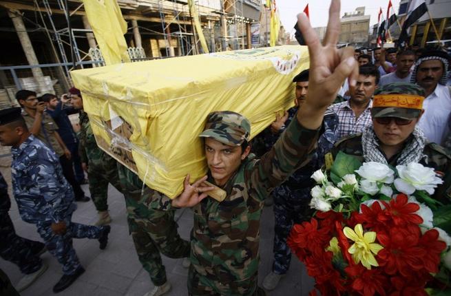 Iraqi soldiers carry the coffin of an Iraqi fighter who belonged to Iraq's Popular Mobilization units and was killed in the town of Baiji during clashes against Daesh