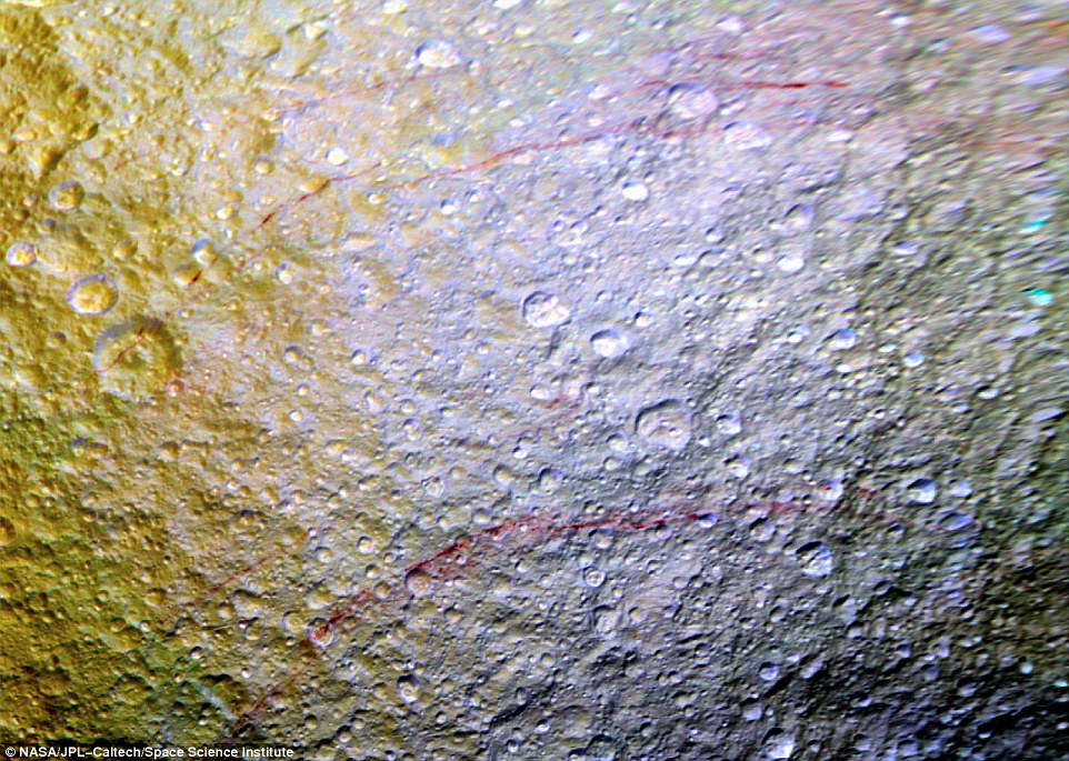 Unusual arc-shaped reddish streaks cut across the surface of Saturn's ice-rich moon Tethys in this enhanced-color mosaic. The red streaks are narrow curved lines on the moon's surface only a few miles wide but several hundred miles long. The red streak