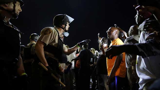 Officers and protesters face off along West Florissant Avenue Monday Aug. 10 2015 in Ferguson Mo. Ferguson was a community on edge again Monday a day after a protest marking the anniversary of Michael Brown's death was punctuated with gunshots