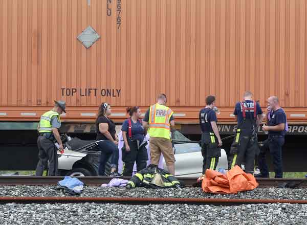 Police and fire officials wait for the Lorain County Coroner to arrive alongside a car that was hit by a train on Reed Road in Eaton Township on Sunday. BRUCE BISHOP  CHRONICLE