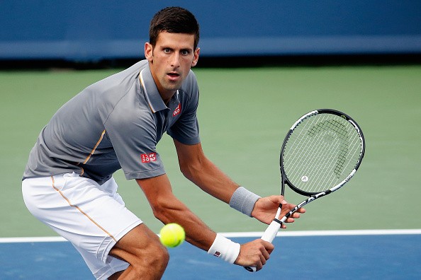 Novak Djokovic attempts a backhand slide in his win over Benoit Paire