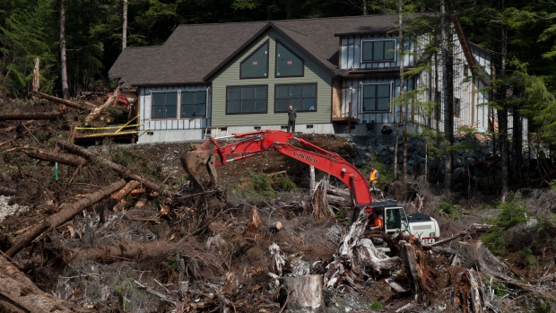 Sitka Alaska City Administrator Mark Gorman stands in front of a house as contractors and other search members look in the area where city building inspector William Stortz was last seen when a landslide hit Bodies of two of three victims of Tu