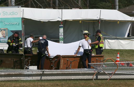 Police and fire officials hold up a sheet a body following a fatal tent collapse at the Prairie Fest in Wood Dale Ill. Sunday Aug. 2 2015. Several people were injured after the tent collapsed at the festival in suburban Chicago according to the Chica