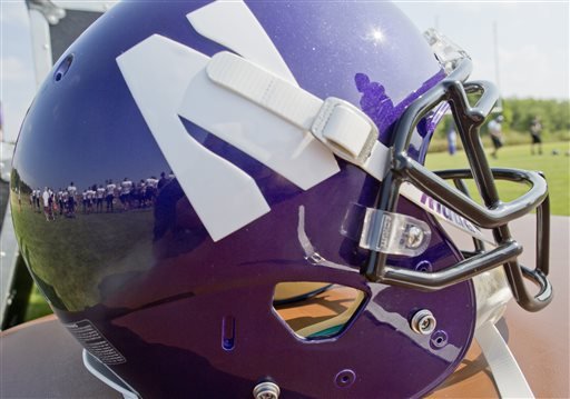 Northwestern football players are reflected in a helmet during drills at practice at the University of Wisconsin Parkside campus on Monday Aug. 17 2015 in Kenosha Wi