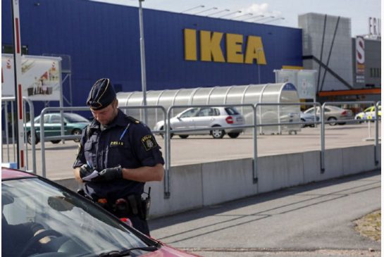 A police office talks to customers outside the Ikea in Vasteras Sweden after three people were stabbed in the store