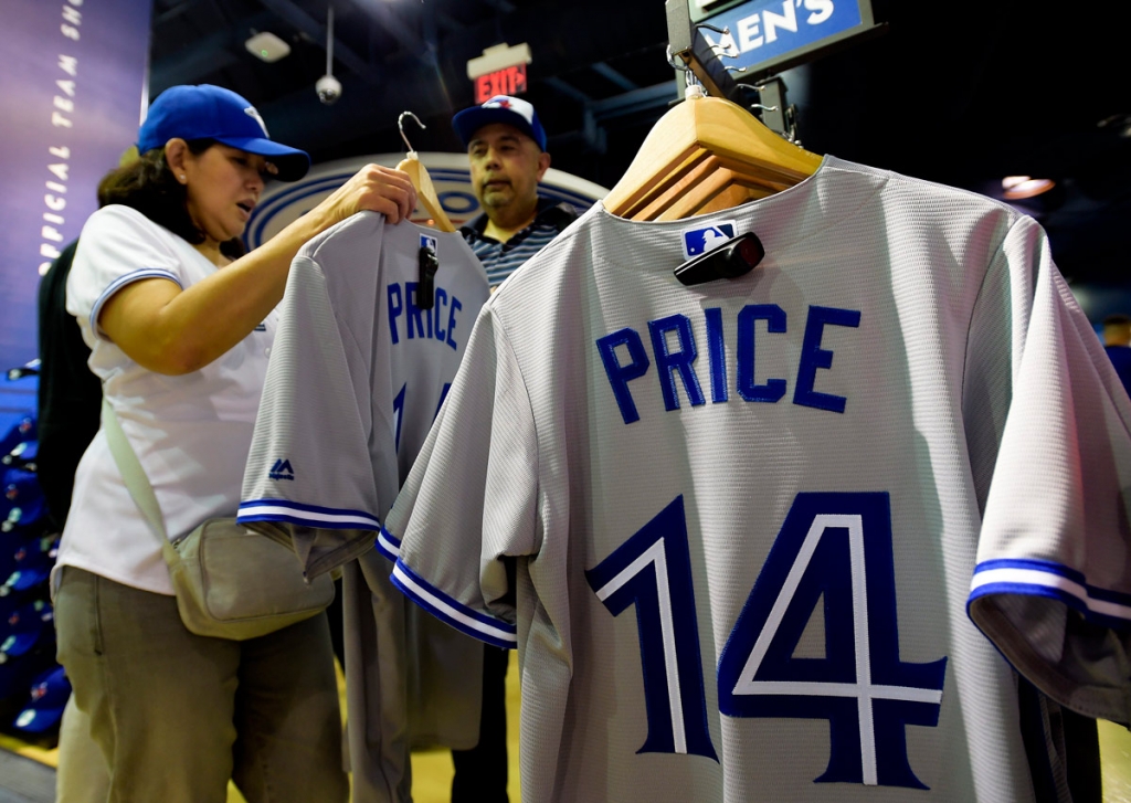 Toronto Blue Jays fans tries on the jersey of newly acquired pitcher David Price before the Blue Jays play the Kansas City Royals during a baseball game