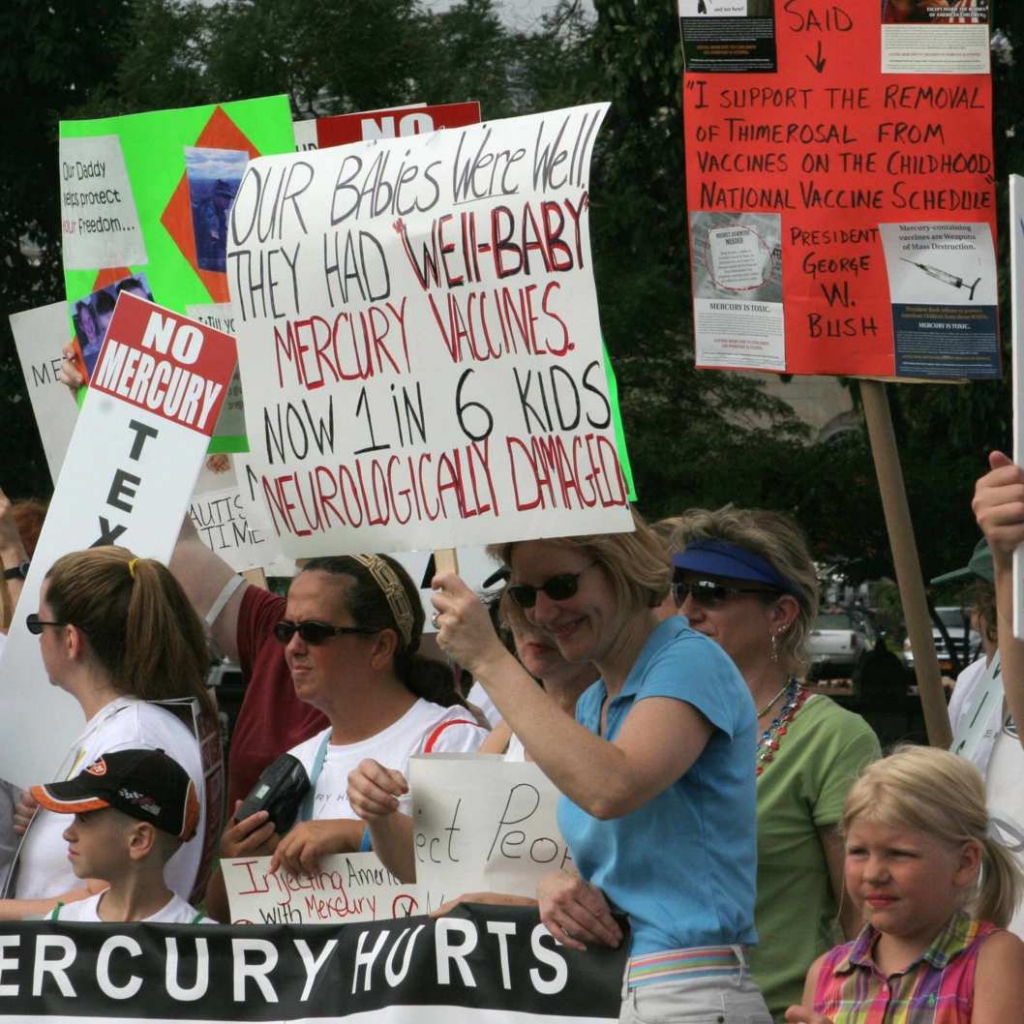 Demonstrators carry signs against the