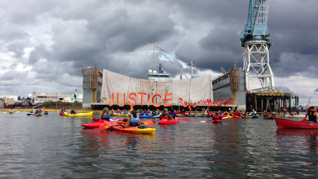 Protesters in kayaks gather by the Portland dry dock where the Fennica sits to oppose drilling in the Arctic