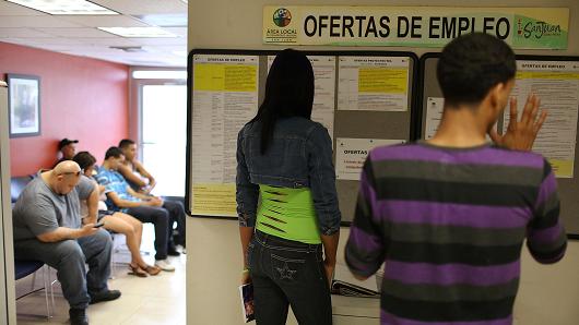 People look at the job listing posted on the wall at an unemployment office a day after the governor gave a televised speech regarding the governments $72 billion debt in San Juan Puerto Rico