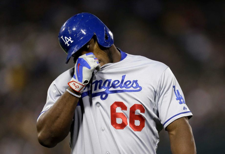 Los Angeles Dodgers Yasiel Puig wipes his face after hitting a fly out against the Oakland Athletics in the sixth inning of a baseball game Tuesday Aug. 18 2015 in Oakland Calif