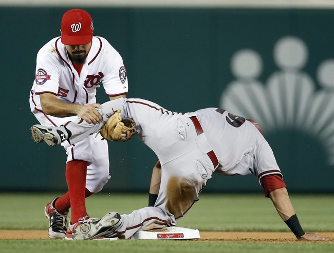 Washington Nationals third baseman Anthony Rendon gets tangled up with Arizona Diamondbacks Jake Lamb who was safe at second base after tagging up at first base during the ninth inning of a baseball game at Nationals Park Tuesday Aug. 4 2015