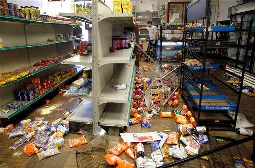 Adam's Market owner Sanad Motan stands inside his ransacked store Thursday Aug. 20 2015 in St. Louis. The store is near where officers arrested several people and deployed tear gas amid protests in St. Louis following the death of a black 18-year-old