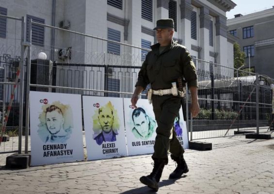 A security officer walks past the portraits