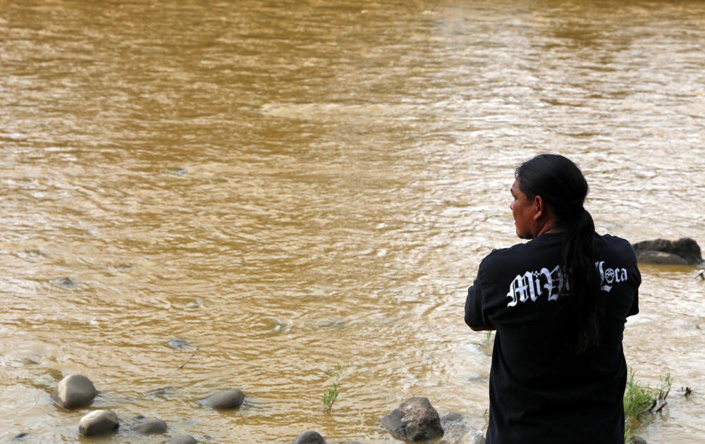 Travis Sells of Farmington looks at the orange sludge flowing past Berg Park. About 1 million gallons of wastewater from Colorado's Gold King Mine began spilling into the Animas River on Wednesday when a cleanup crew supervised by the EPA accidentall