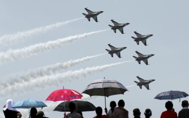 People wave national flags during Singapore's 50th National day anniversary celebration at the Padang in Singapore