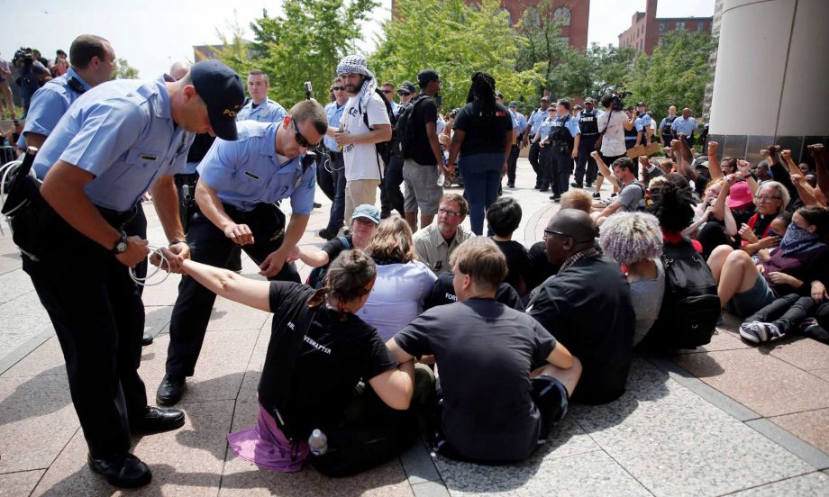 St. Louis police arrest a protester outside the Thomas F. Eagleton Federal Courthouse Monday Aug. 10 2015 in St. Louis. Protesters have been arrested after blocking the entrance to the St. Louis federal courthouse while calling for more aggressive U.S