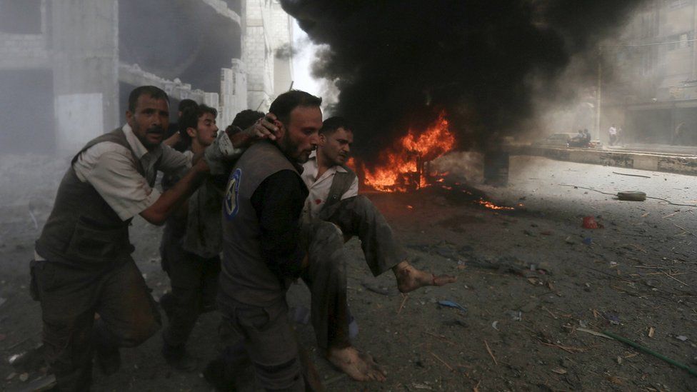 Syrian Civil Defence rescue workers carry a wounded man after what activists said was a government air strike in the rebel-held Damascus suburb of Douma