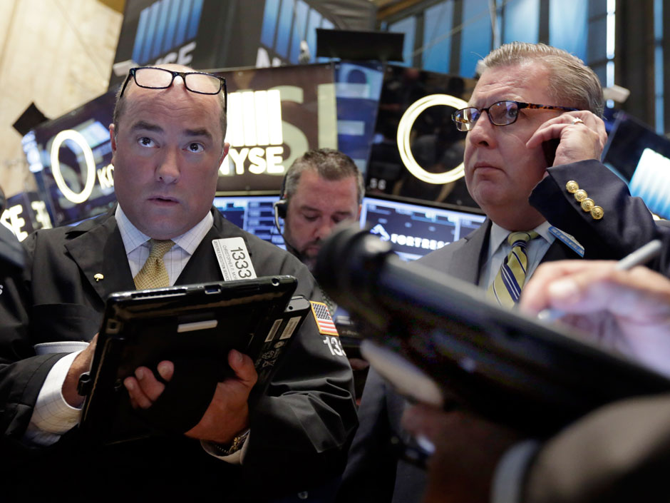 Traders work on the floor of the New York Stock Exchange. North American markets closed lower on Tuesday