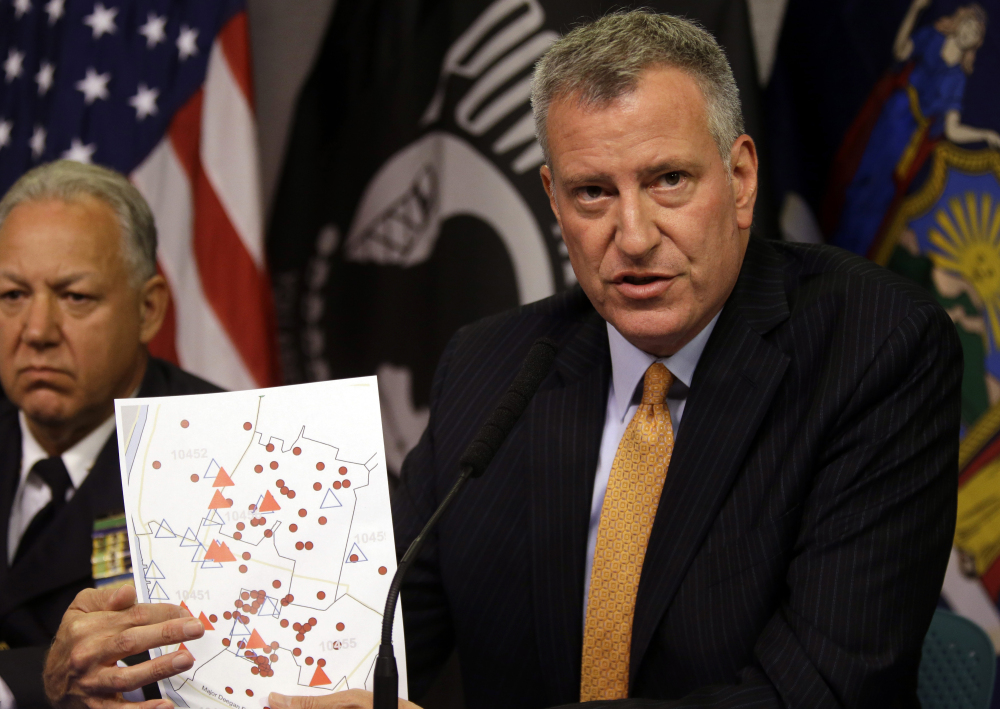 New York City Mayor Bill de Blasio holds a map showing the location in the Bronx borough of cooling towers red triangles and people red dots that were infected with Legionnaires’ disease