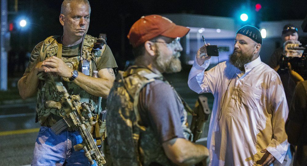 Members of the Oath Keepers walk with their personal weapons on the street during protests in Ferguson Missouri