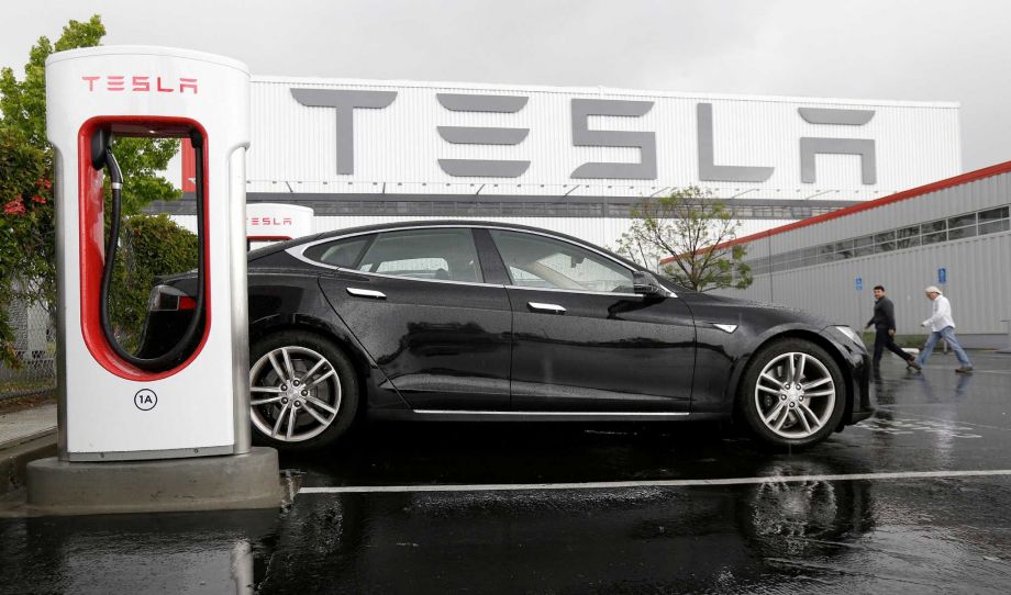 Tesla vehicle is parked at a charging station outside of the Tesla factory in Fremont Calif. Tesla reports quarterly financial results on Wednesday Aug. 5 2015